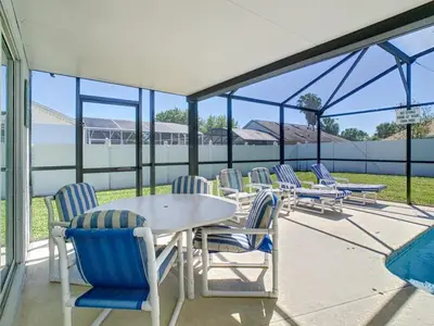 a group of chairs sitting around a table on a patio at Relax Away Villa: Private Pool Home Near Disney in Orlando