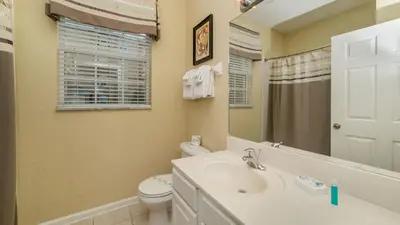 a bathroom with a sink and a toilet and a mirror at ALM2781-103 in Orlando