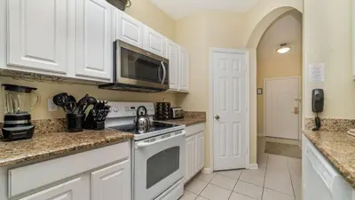 a kitchen with white cabinets and a microwave at ALM2781-103 in Orlando