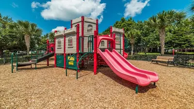 a playground with a red slide in a park at ALM2821-204 in Orlando