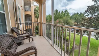 a balcony with two chairs and a view of a yard at ALM2821-204 in Orlando