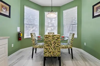 a dining room with green walls and a table and chairs at DVL2638 in Orlando
