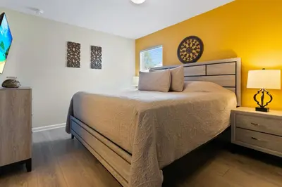 a bedroom with a large bed and a yellow wall at DVL2638 in Orlando