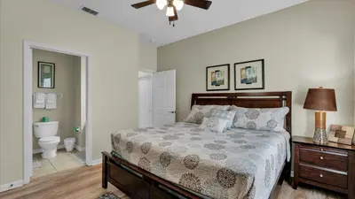 a bedroom with a bed and a bathroom with a toilet at FP8176 Windsor Palms Resort Vacation Home in Kissimmee