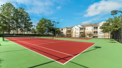 a tennis court with a net in front of condos at FP8190 Windsor Palms Resort Vacation Home in Kissimmee