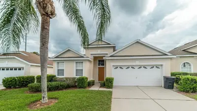 a house with a palm tree in front of it at FP8208 Windsor Palms Resort Vacation Home in Kissimmee