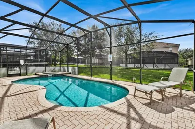 a swimming pool with a pergola and a chair and a table at GRS7756 in Orlando