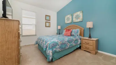 a bedroom with a bed and a dresser and a window at FP8150 Windsor Palms Resort Vacation Home in Kissimmee