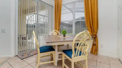 a dining room with a table and chairs and a window at FP8150 Windsor Palms Resort Vacation Home in Kissimmee