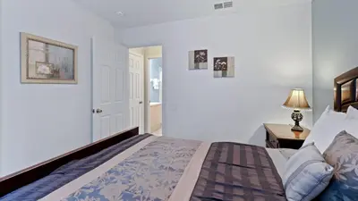 a bedroom with a bed and a lamp on a table at FP8159 Windsor Palms Resort Vacation Home in Kissimmee