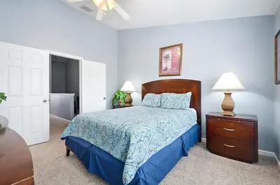 a bedroom with a bed and a dresser and two lamps at Luxury 3-bdr house with pool next to Disney in Orlando