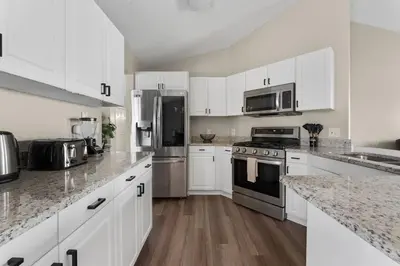 a kitchen with white cabinets and stainless steel appliances at New Listing Pool and Game Room 4BR in Orlando
