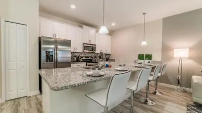 a kitchen with a bar with chairs and a counter top at PEQ3141 in Kissimmee