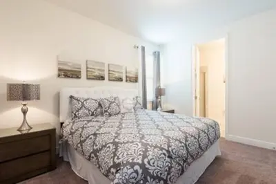 a bedroom with a bed and a lamp and a nightstand at Contemporary Disney VacationHome in Orlando
