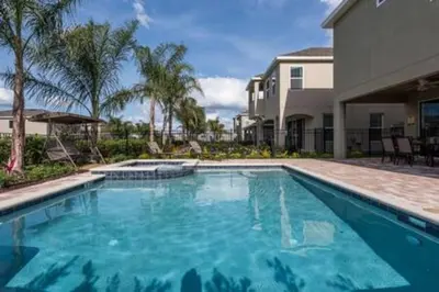 a large swimming pool in front of a house at Contemporary Disney VacationHome in Orlando