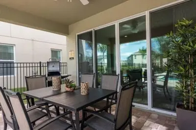 a dining room with a table and chairs on a patio at Contemporary Disney VacationHome in Orlando