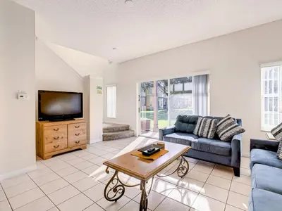 a living room with a couch and a tv at Spacious Emerald Escape - 12 Mins to Disney in Kissimmee