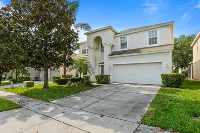 a white house with a tree and a driveway at Windsor Hills Resort Vacation Home TS7718 in Orlando