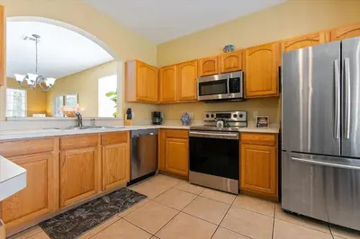 a kitchen with wooden cabinets and a stainless steel refrigerator at Windsor Hills Resort Vacation Home TS7718 in Orlando