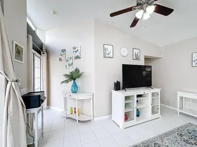 a living room with a flat screen tv on a wall at Stunning 5BR 5Bath Home, Pool, Spa, By Disney in Kissimmee