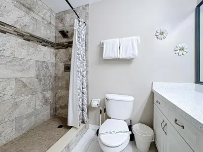 a white bathroom with a toilet and a shower at Stunning 5BR 5Bath Home, Pool, Spa, By Disney in Kissimmee