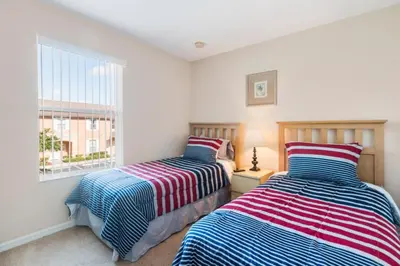 two beds in a room with a window at Spacious Regal Oaks Retreat - Steps to the Pool in Orlando
