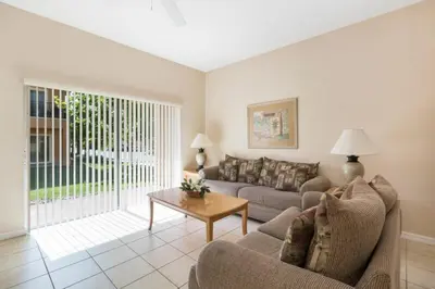a living room with a couch and a table at Spacious Regal Oaks Retreat - Steps to the Pool in Orlando