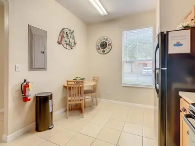 a kitchen with a refrigerator and a table and a window at Spacious Regal Oaks Townhome by Disney in Orlando