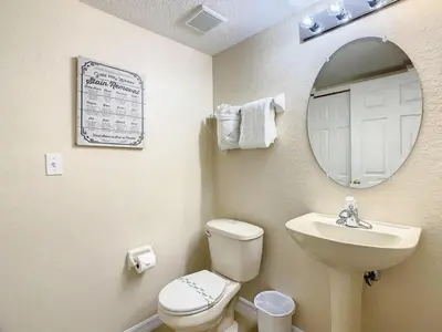 a bathroom with a toilet and a sink and a mirror at Spacious Regal Oaks Townhome by Disney in Orlando