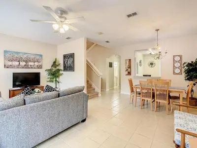 a living room with a couch and a dining room at Spacious Regal Oaks Townhome by Disney in Orlando
