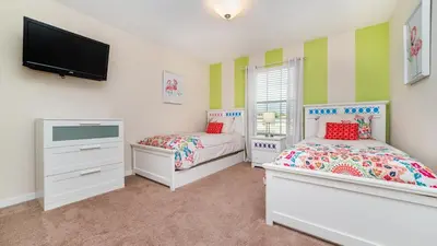 a bedroom with two beds and a flat screen tv at BCH3027 in Kissimmee