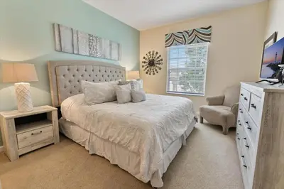 a bedroom with a bed and a chair and a television at CP8107-305 Windsor Palms Resort Vacation Condo in Orlando