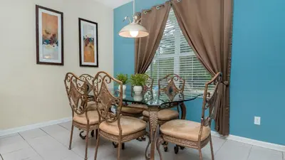 a dining room with a glass table and chairs at CW7719 Windsor Hills Resort Vacation Home in Orlando