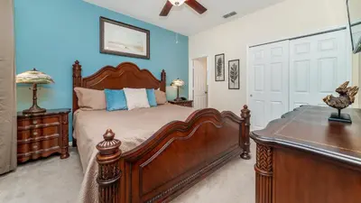 a bedroom with a large wooden bed and blue walls at CW7719 Windsor Hills Resort Vacation Home in Orlando
