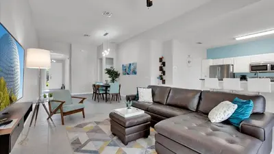 a living room with a leather couch and a dining room at CW7739 Windsor Hills Resort Vacation Home in Orlando