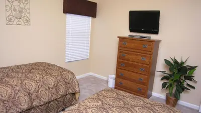 a bedroom with a bed and a dresser with a tv at DB2605 Windsor Hills Resort Vacation Home in Orlando