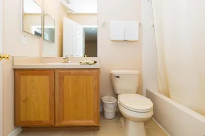 a bathroom with a toilet and a sink and a tub at Stunning Regal Oaks 4BR w/ Pool, Spa & Near Disney in Orlando
