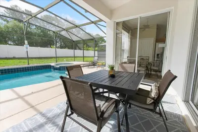 a patio with a table and chairs next to a pool at Windsor Palms Resort Vacation Home WP2209 in Kissimmee