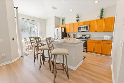 a kitchen with wooden cabinets and bar stools at Windsor Palms Resort Vacation Home WP2209 in Kissimmee