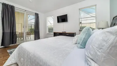 a white bedroom with a bed and a tv at Windsor Palms Resort Vacation Home WP2243 in Kissimmee