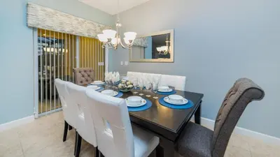 a dining room with a black table and white chairs at CAP8875 in Kissimmee