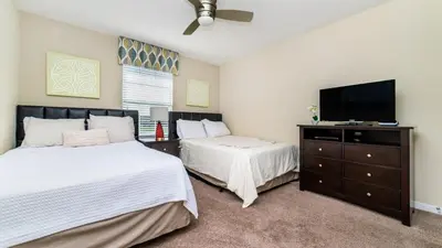 a bedroom with two beds and a flat screen tv at CAP8875 in Kissimmee