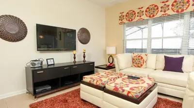 a living room with a white couch and a tv at Luxury 6 BR in Windsor Hill Resorts in Orlando