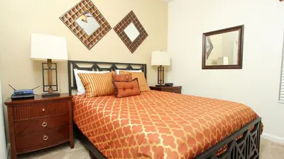 a bedroom with a bed and a dresser and a mirror at Luxury 6 BR in Windsor Hill Resorts in Orlando