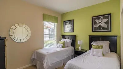 two beds in a room with green walls at Lavish 4BR Home in Windsor Hills Resort in Orlando