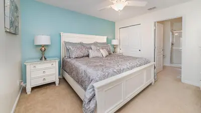 a bedroom with a bed and a night stand with a lamp at Huge 6BR Home in Windsor Hills Resort in Orlando