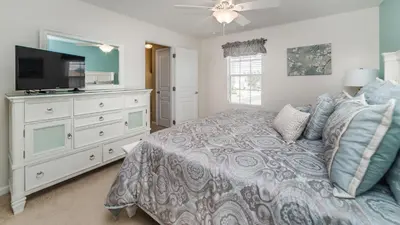 a bedroom with a bed and a flat screen tv at Huge 6BR Home in Windsor Hills Resort in Orlando