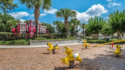 a playground with yellow toy dogs and a swing at Huge 6BR Home in Windsor Hills Resort in Orlando