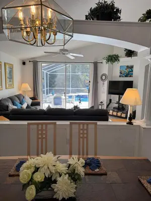 a living room with a couch and a table with flowers at Disney area 4-bedrooms spacious villa for rent in Kissimmee