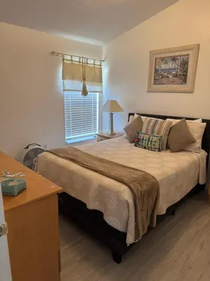 a bedroom with a large bed with a window at Disney area 4-bedrooms spacious villa for rent in Kissimmee